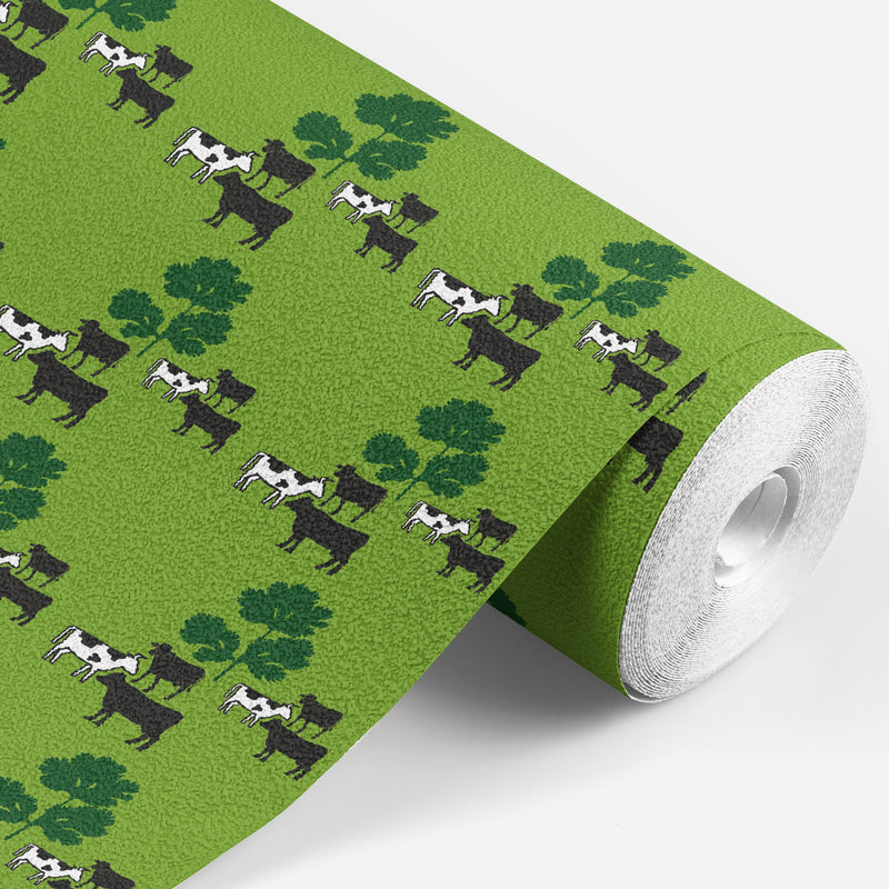 roll of Green wallpaper with black and white cows standing around some green parsley 