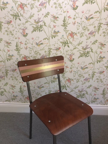 Striped chair in front of bird wallpaper