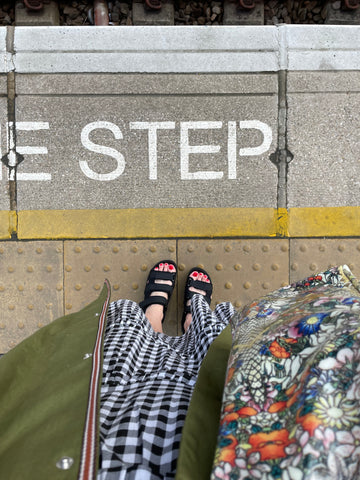 Gingham dress, green trench, black strappy sandals. Mind the step at platform